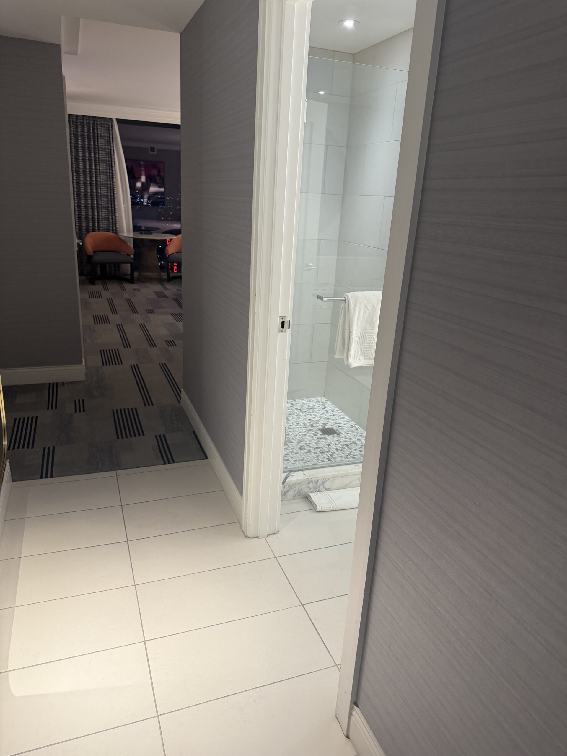 Walk-in shower with pebble stone floor in the Fontainebleau Las Vegas suite bathroom