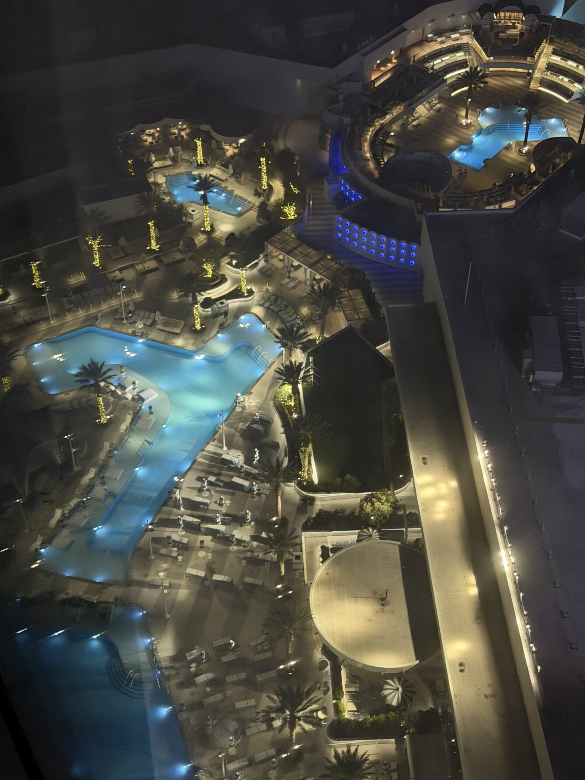 Aerial night view of the Fontainebleau Las Vegas pool district with illuminated pools and palm trees