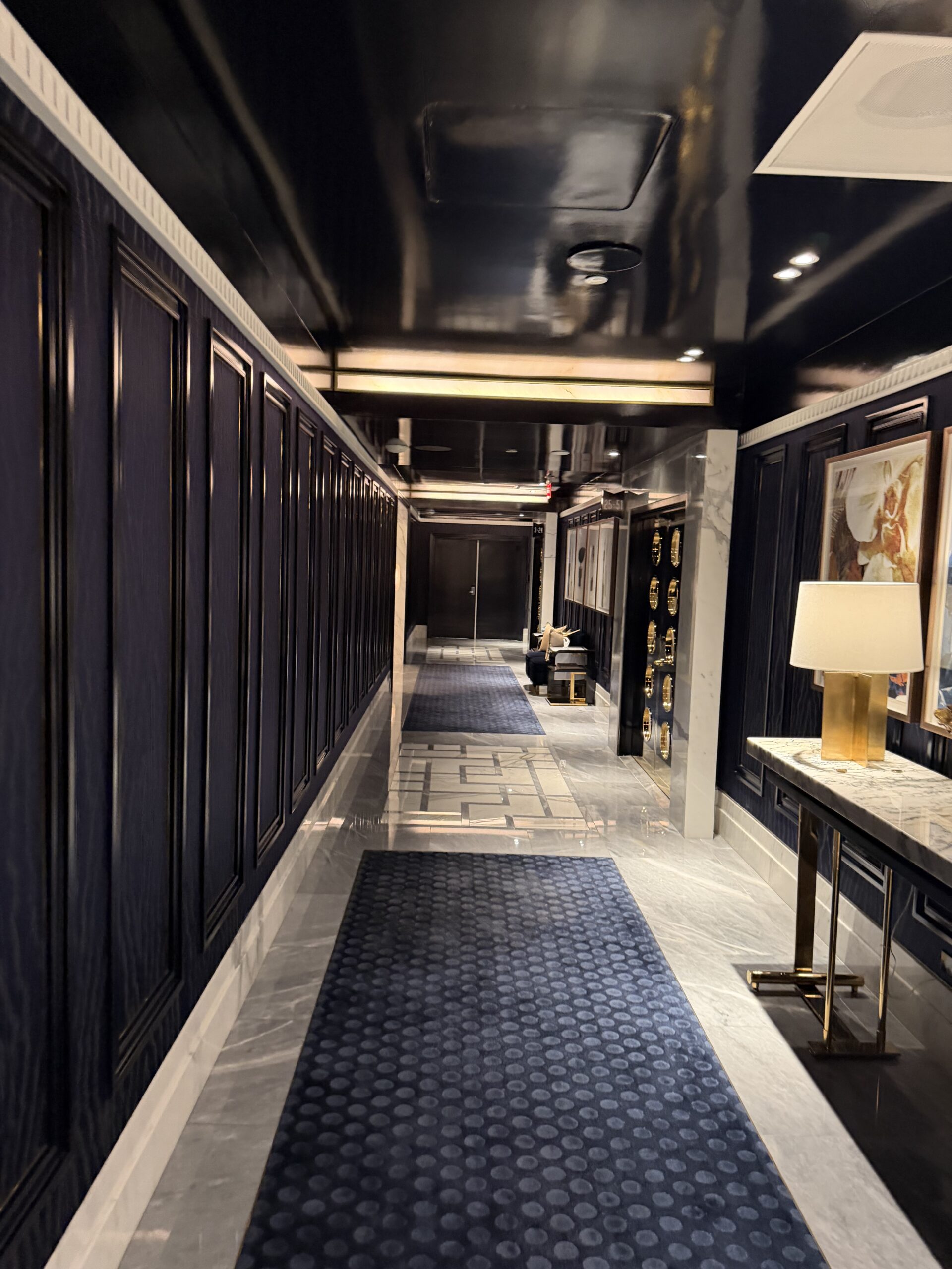 Hallway with navy paneled walls and marble floors at Fontainebleau Las Vegas