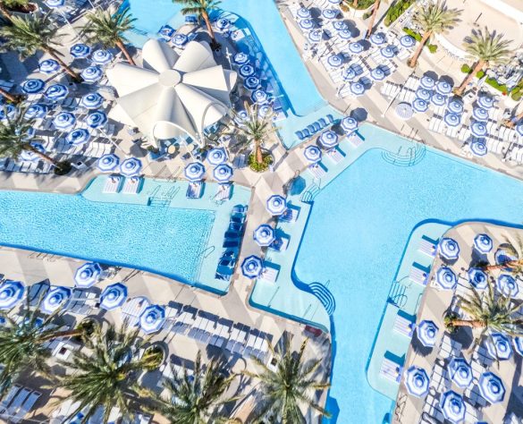 Aerial view of the Fontainebleau Las Vegas Oasis Pool Deck with striped umbrellas and palm trees