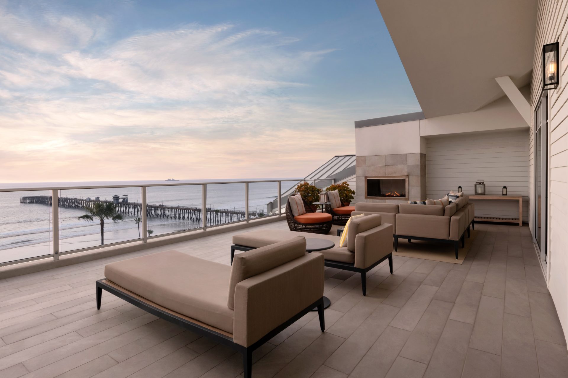 Estate Suite patio at The Seabird with an outdoor fireplace and a sunset view of the Oceanside Pier